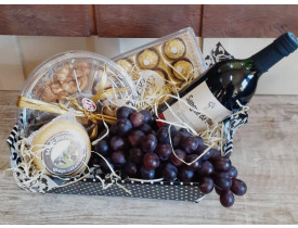 Linda cesta contendo uma petisqueira de amendoins, 01 caixa de Ferrero Roche com 12 unidades, 01 un de queijo (podendo variar entre brie, gorgonzola, ou gouda) de aproximadamente 150 gr, 01 vinho nacional, e um cacho de uva (poderá ser substituída por out