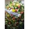 Linda coroa de flores, composta por flores do campo e rosas, (aproximadamente 15 rosas, cores conforme disponibilidade), tango, verdes.  Acompanha pedestal para a colocação do arranjo e faixa de homenagem.
